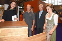 Forstministerin Michaela Kaniber, Hans Aumüller, Konrad Steininger, Präsident des Bayerischen Schreinerhandwerks und Waldkönigin Johanna Gierl begutachten den Stehtisch 'Covertino'.