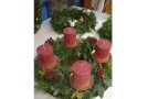 Adventskranz aus verschiedenen Zweigen mit roten Kerzen