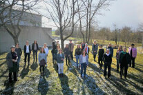 Viele Personen stehen im Schulgarten