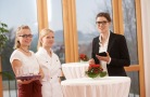 drei Frauen stehen an einem runden Tisch