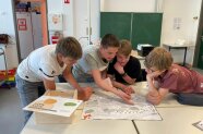 Schüler betrachten Wimmelbild