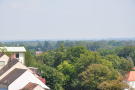 Blick von oben auf Siedlung im Vordergrund und von dort bis zum Horizont reichenden Baumbestand.