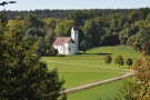 Aussicht auf eine im Wiesental gelegene kleine Kirche.