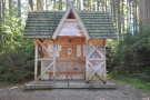 Einem Keltenhaus nachempfundene, nach vorne offen stehende Hütte im Wald.