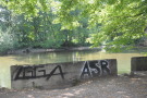 Graffiti an einer Betonmauer am Fluss im Erholungswald