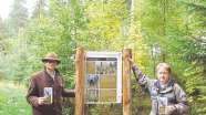 Waldbesitzer Clemens Trebra-Lindenau und Forstamtsleiter Hans-Jürgen Gulder neben InformationstafelInfotafel im Vorzeigewald