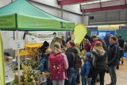 viele Personen stehen vor einem Messestand