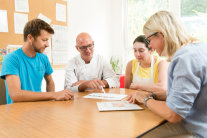 Zwei Männer und zwei Frauen sitzen um Tisch und schauen auf Blatt Papier © Tobias Hase, StMELF