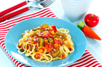 Spaghetti mit Gemüsesoße auf einem Teller 
