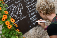 Frau beschriftet Tafel mit Getränkeangebot © Angelika Warmuth / StMELF